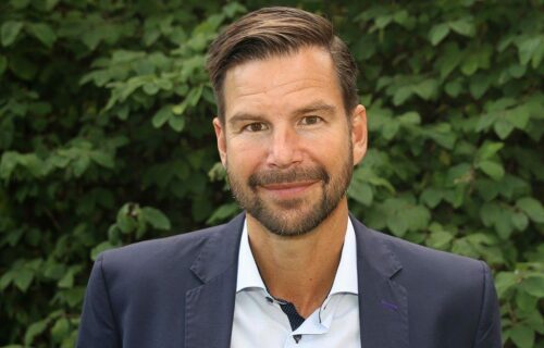 Porträttfoto av Ola Hansén, klimatexpert. Iklädd kavaj, vit skjorta och lätt leendes mot kameran.