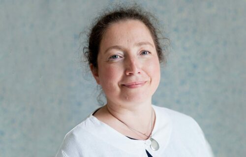 Porträttfoto av Lovisa Hagberg, leendes mot kameran iklädd vit tröja.