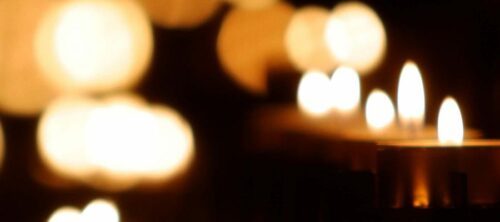 Närbild på värmeljus mot glittrande bakgrund.