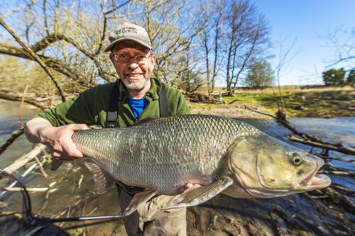 Fiskebiolog Johan Persson med en femkilosasp i Örsundaån i Enköping. Foto: Ola Jennersten