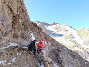 Två personer i ett snöklätt berglandskap.