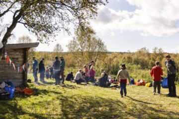 Personer fikar på en stor grönyta.