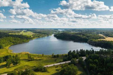 Flygfoto över sjö och skog vid Ogestad Egendom och Hyllela gård, Västerviks kommun, Småland, Sverige