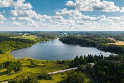 Flygfoto över sjö och skog vid Ogestad Egendom och Hyllela gård, Västerviks kommun, Småland, Sverige