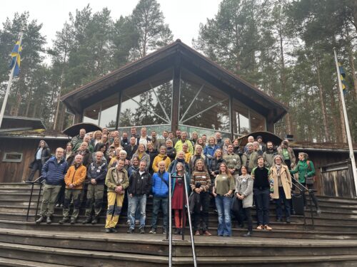Gruppbild från Rovdjurssymposium. Gruppen står samlade på en trappa framför en brun byggnad.