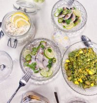 Bilder på ett påskbord med tre burkar med sill och örtslungad potatis med gravad äggula.